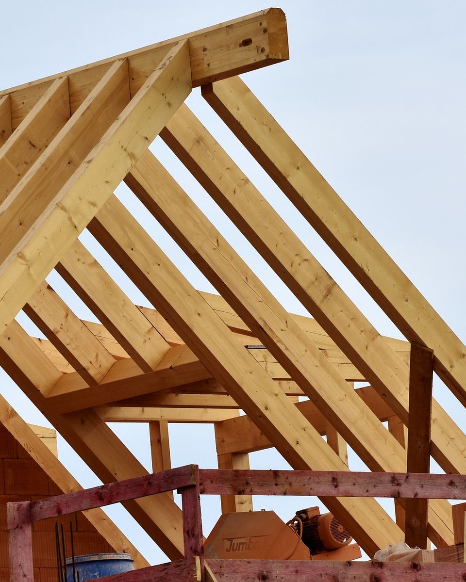 Neuer Dachstuhl aus Holz vor blauem Himmel