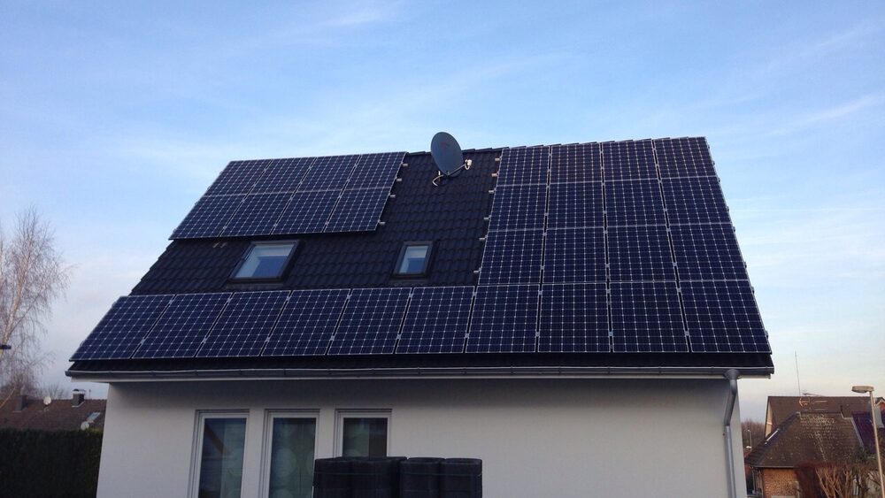 Photovoltaikanlage auf dem Steildach eines Einfamilienhauses mit dunkler Eindeckung und zwei Dachfenstern